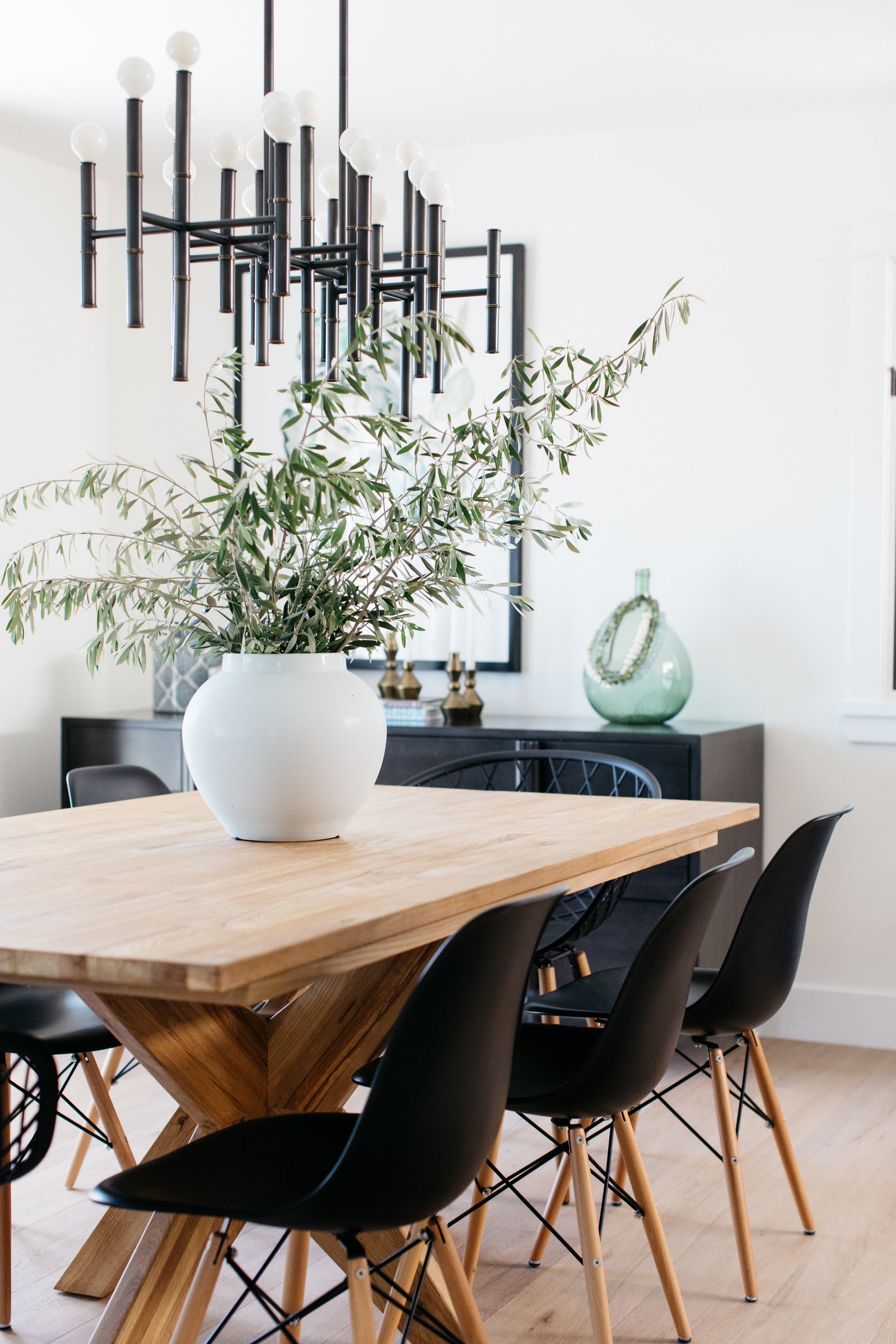 greige design shop + interiors laguna beach cottage dining room black dining chairs natural wood robert abbey chandelier black